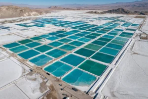 Turquoise lithium brine evaporation ponds on a white salt flat in the Atacama desert